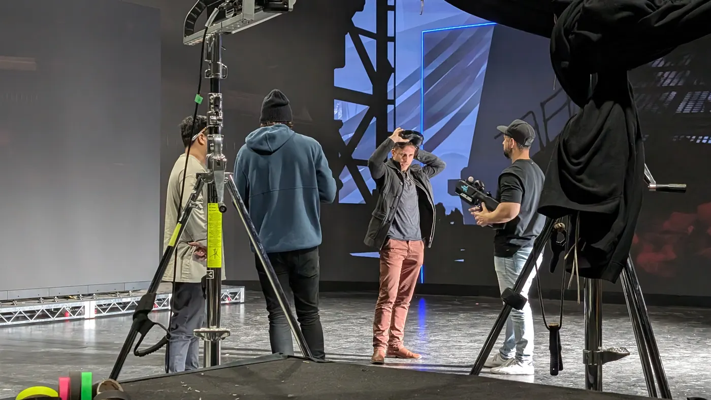 An actor lifts off a VR headset between takes on the LED stage