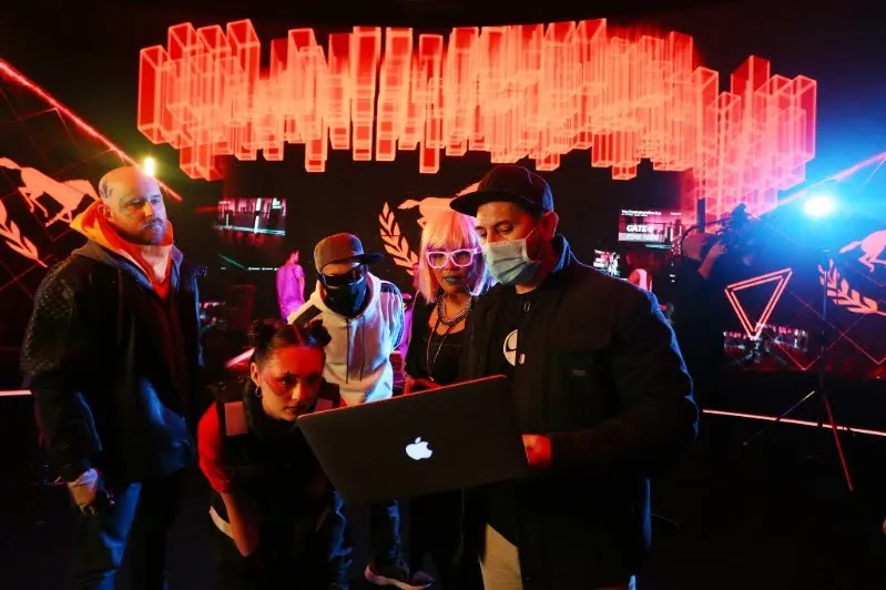 Reviewing takes on a laptop on a neon-lit set